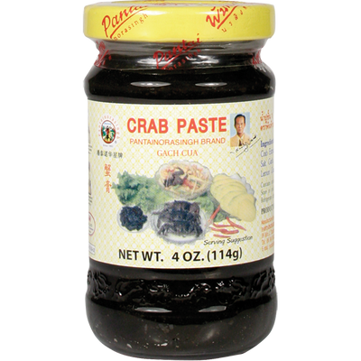 Glass jar of Pantai Norasingh brand fermented crab paste, 4 oz (114g), with a yellow lid and labeled in English and Thai.